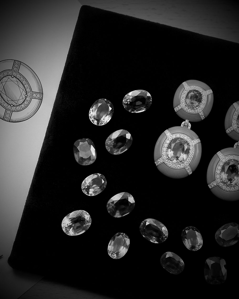 Gemstones and diamond-studded jewelry arranged on a black velvet display.